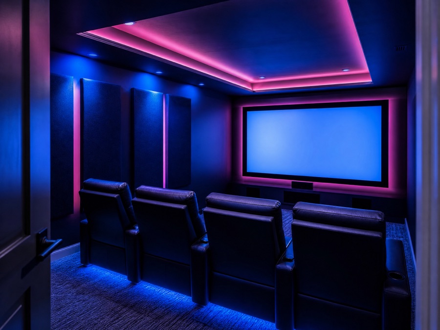 A finished compact home theatre with recliners and a glowing screen